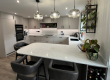 Bespoke fitted kitchen in Durham with grey cabinetry, quartz island and pendant lighting by Dragonville Interiors