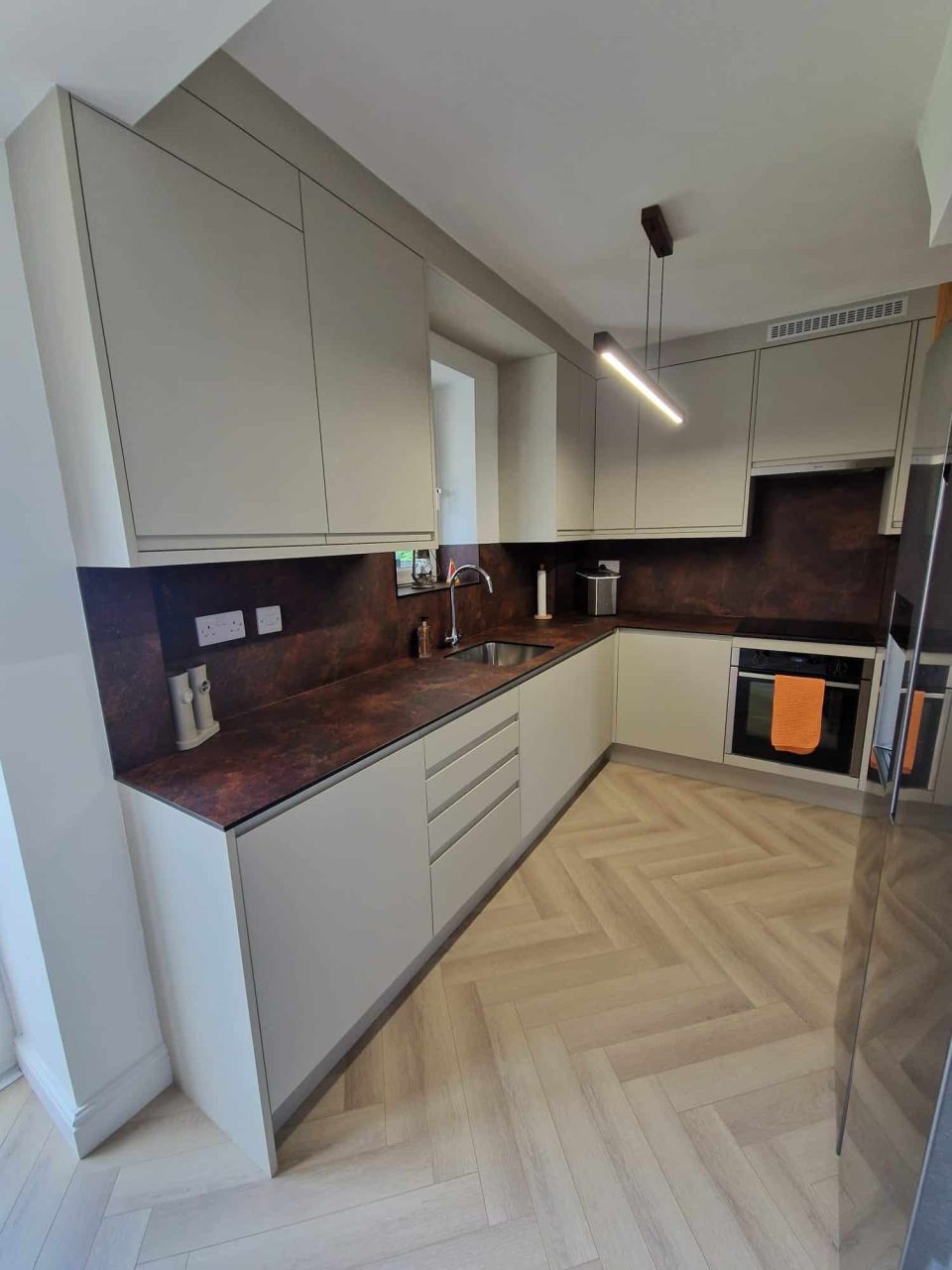 kitchen Matt Taupe bespoke kitchen in Durham with ceramic rust compact laminate worktops and full-height splashbacks